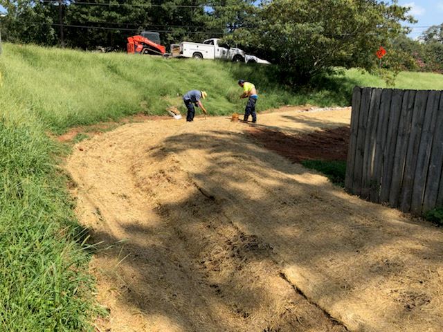 Two people working on a dirt path
