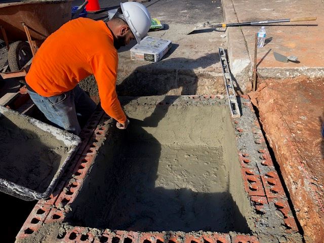 Someone laying concrete and brick