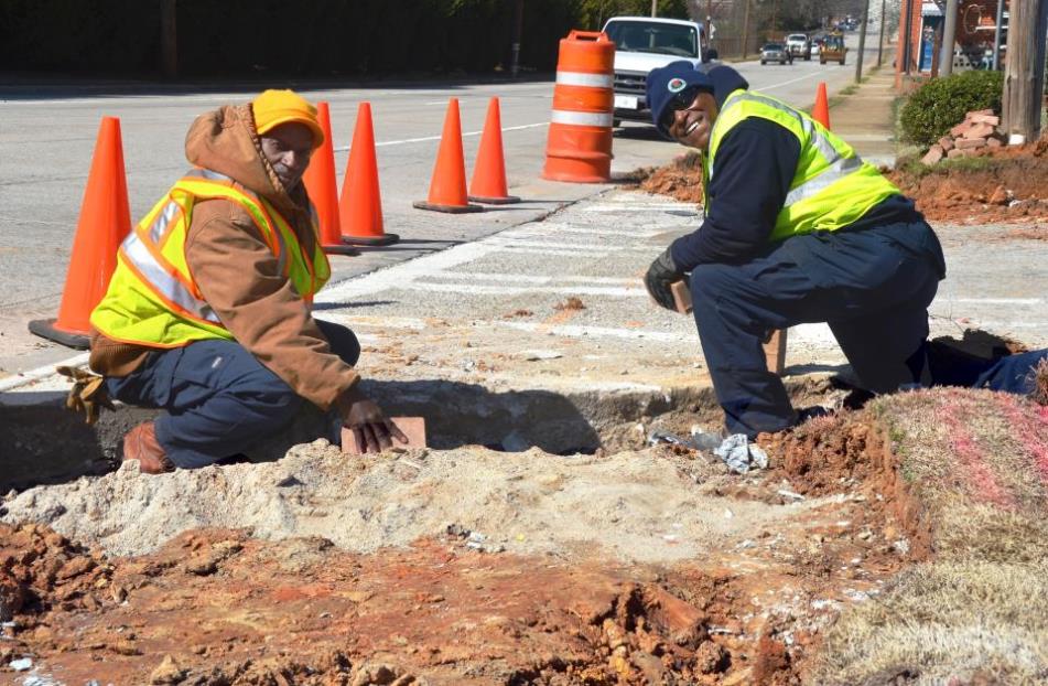 Two people sitting on the ground working
