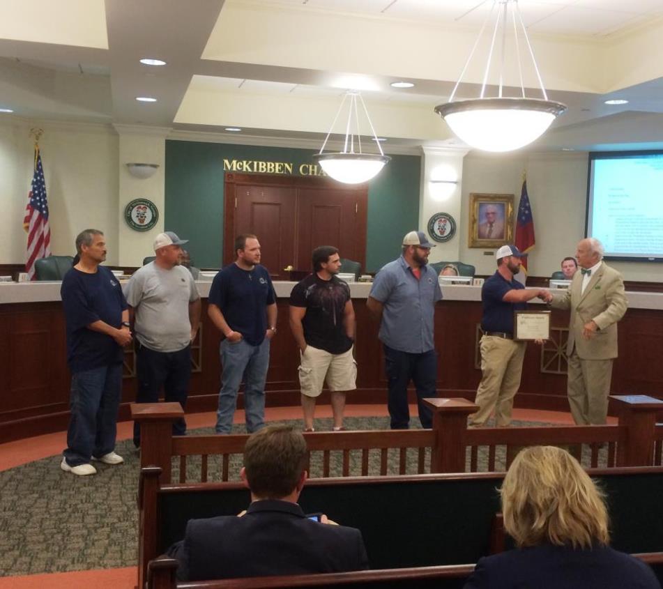 People standing in City Hall chambers